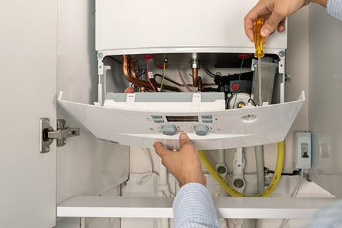 HVAC technician repairing an indoor boiler in Eagle Mountain