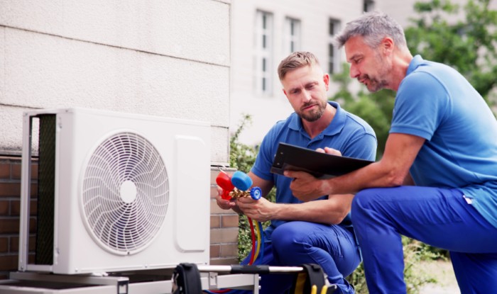 HVAC technicians installing an outdoor air conditioning unit in Eagle Mountain