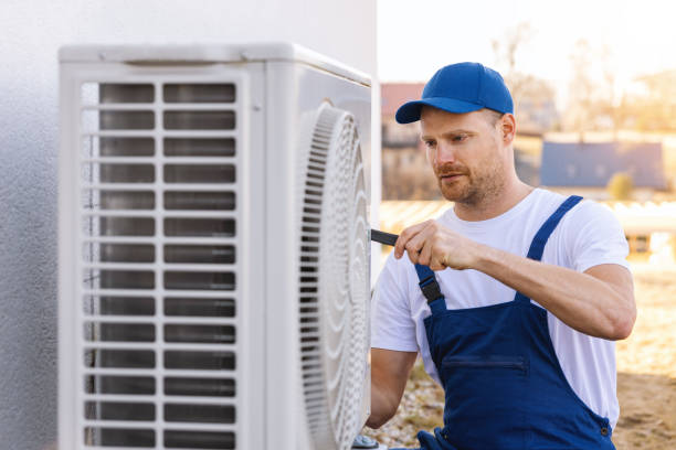 HVAC technician servicing an outdoor air conditioning unit in Eagle Mountain