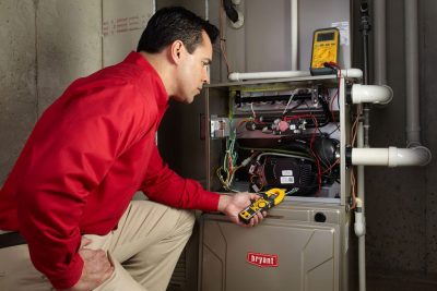Heating and air conditioning technician servicing an indoor furnace in Eagle Mountain, UT